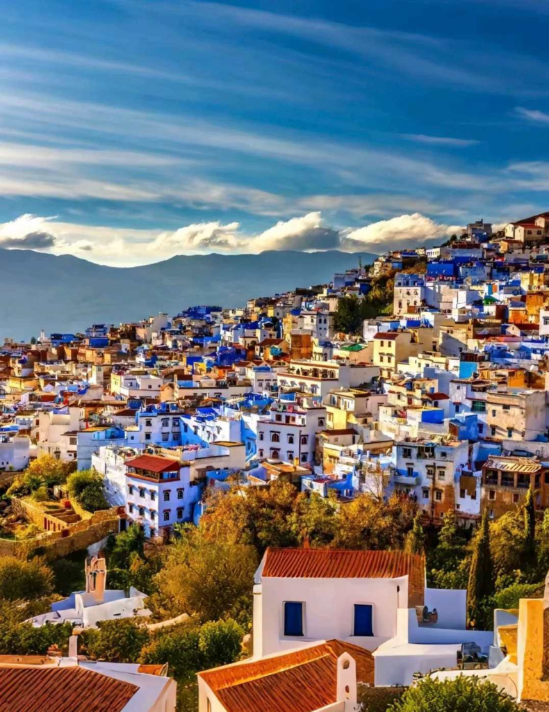 Panoramic view of Chefchaouen blue painted houses cascading down mountainside with traditional Moroccan architecture