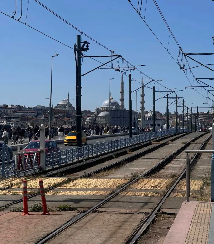 Tram tracks crossing bridge with historic mosques and Istanbul skyline in background