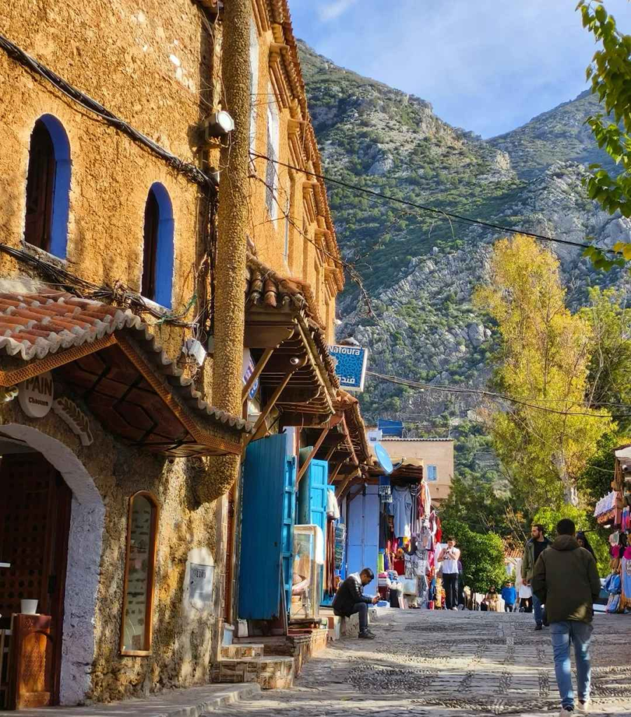 Colorful mountain town street in Morocco Atlas region with traditional blue architecture and local shops