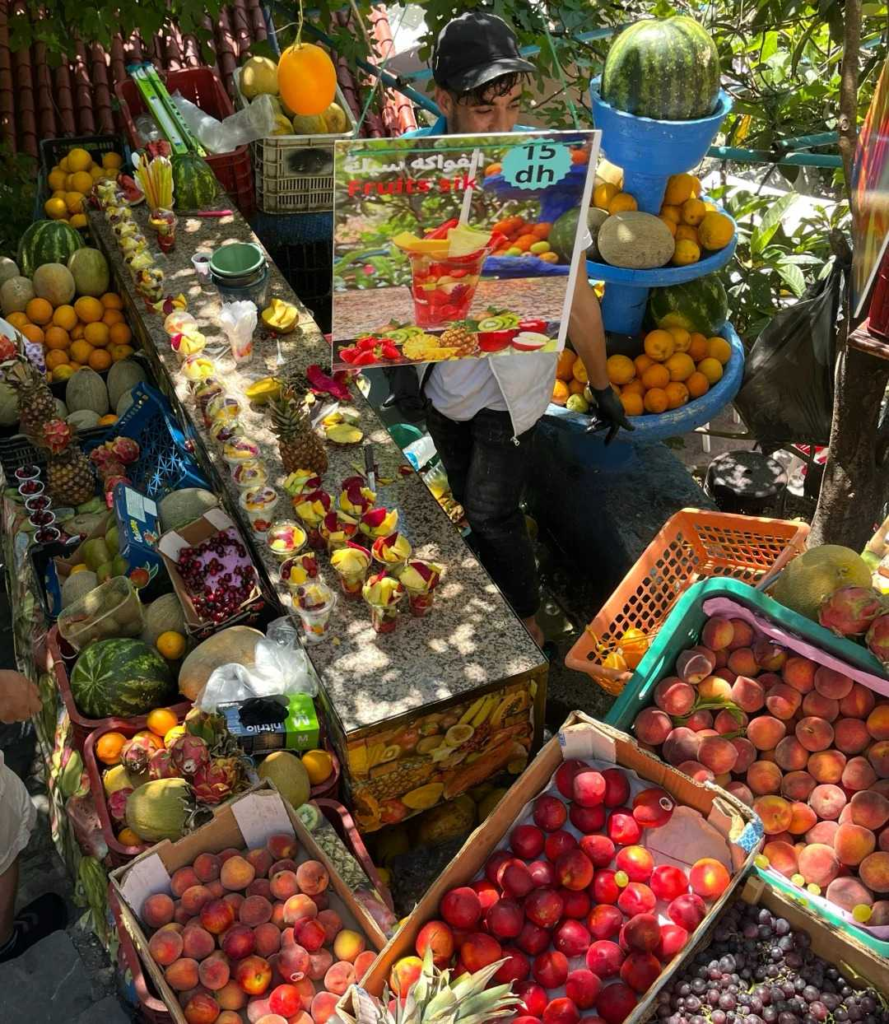 Vibrant Moroccan fruit market stall with oranges melons and seasonal fruits displayed by local vendor