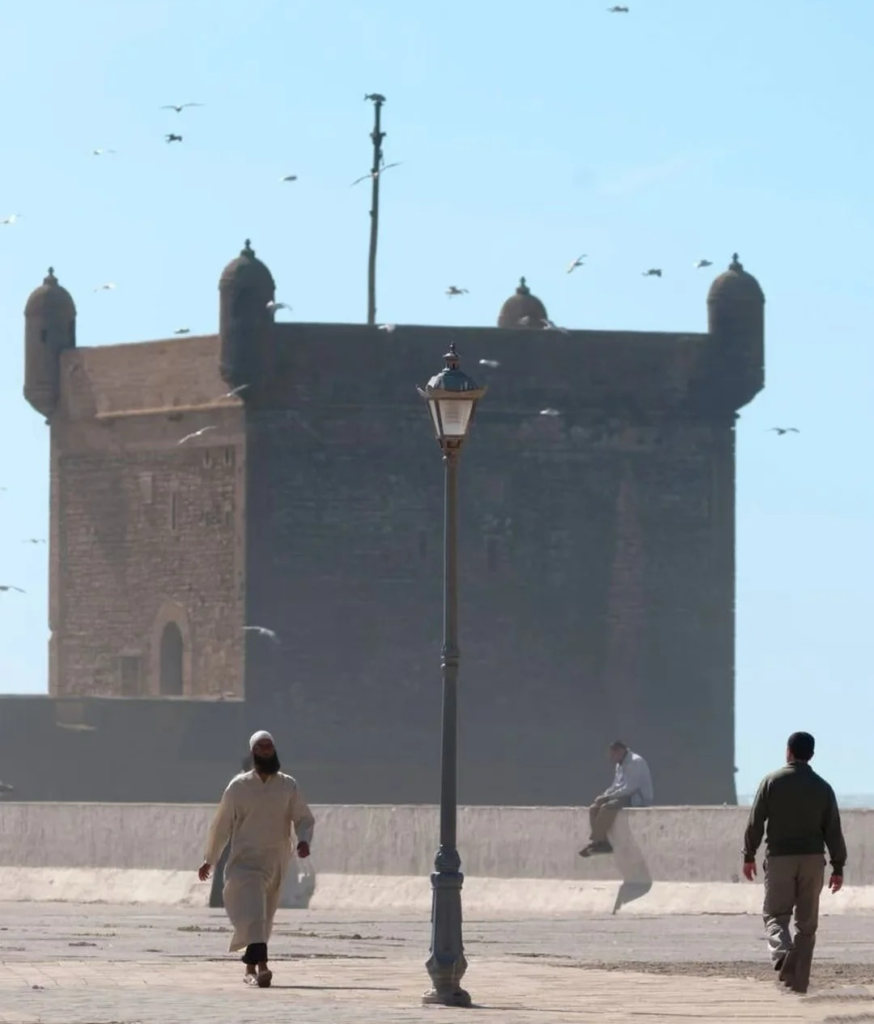 Traditional Moroccan fortress with local people walking in courtyard showcasing authentic daily life