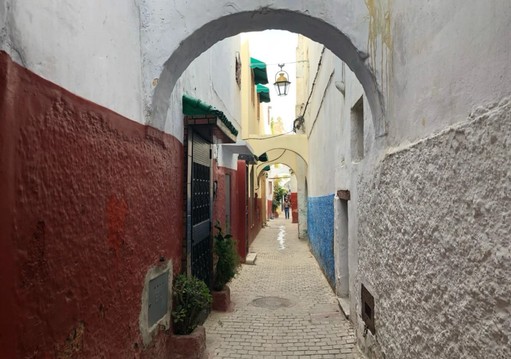 Traditional Moroccan medina alleyway with arched passages and colorful walls where tourists need navigation safety awareness