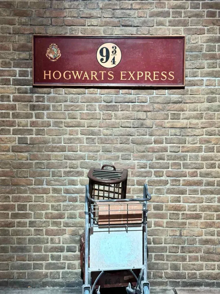 Platform 9¾ brick wall with luggage trolley disappearing through magical barrier