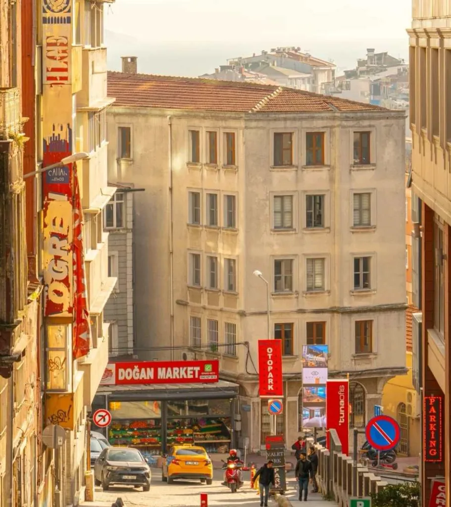 Narrow street in Turkey showing traditional buildings, local shops including Dogan Market, and everyday urban life