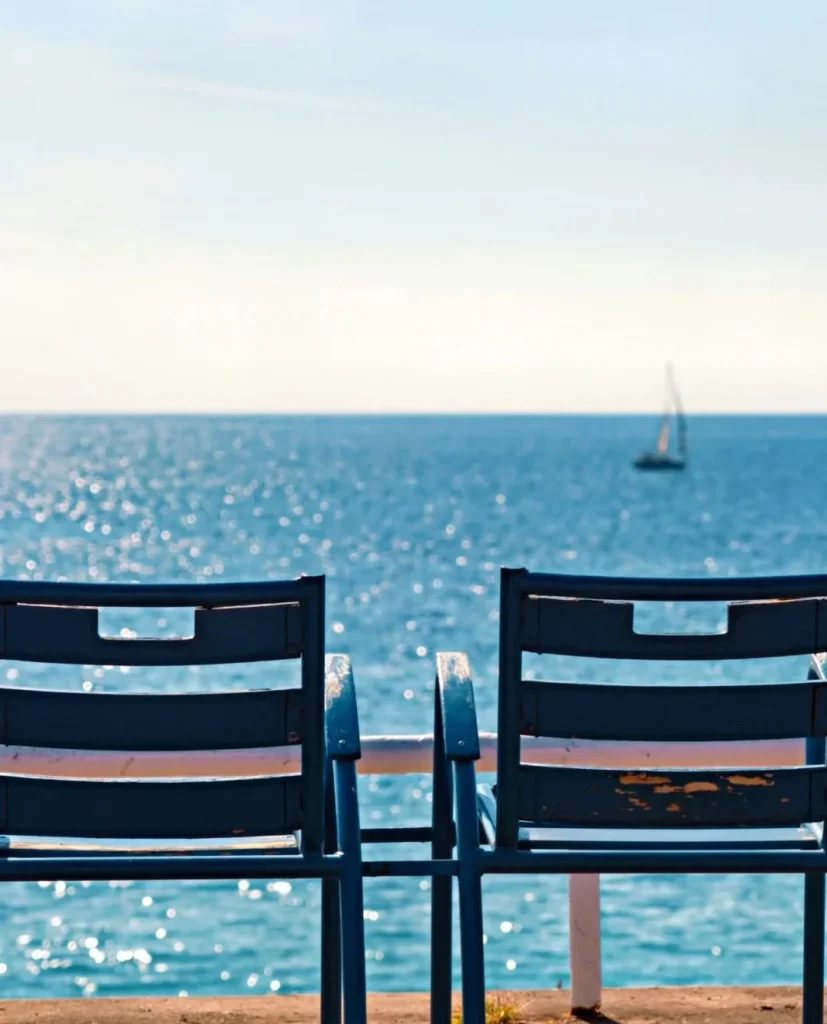 Two blue beach chairs, ocean view, solo travel contemplation.