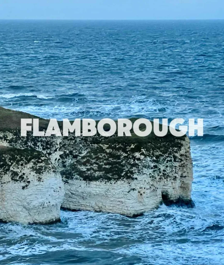 Dramatic white chalk cliffs and sea stacks at Flamborough Head on Yorkshire coast with blue North Sea waters