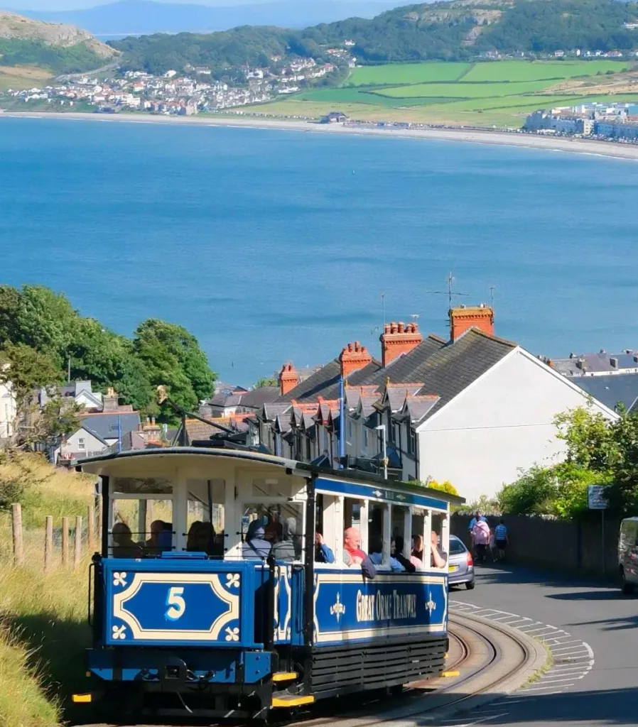 Great Orme Tramway car number 5 descending hillside with stunning views of Llandudno Bay and Victorian terraced houses