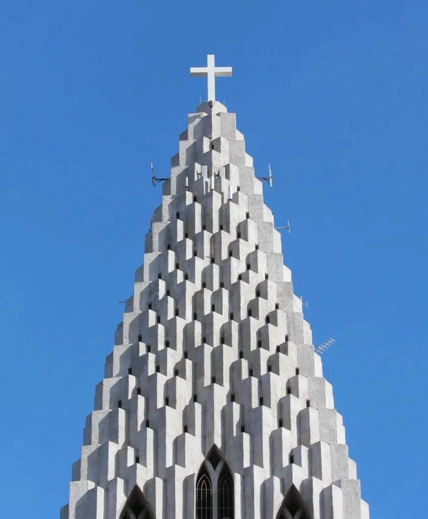 Close-up of Hallgrimskirkja church tower with distinctive concrete basalt column design against blue sky