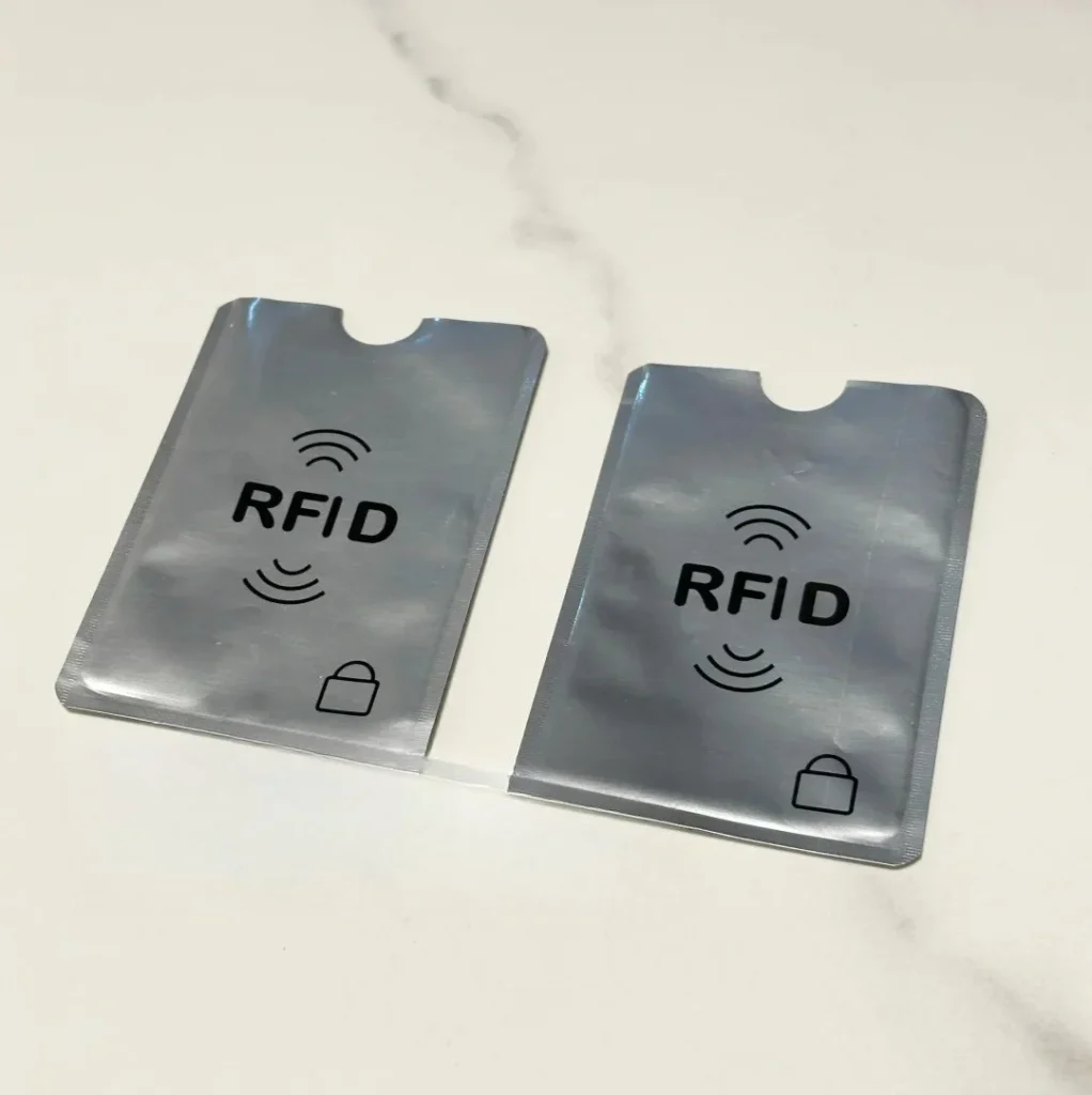 Two metallic RFID blocking card sleeves with lock symbols designed to prevent digital pickpocketing