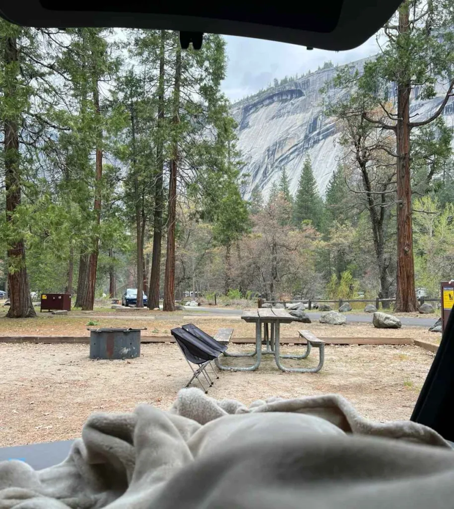 Minimalist camping setup at Yosemite with granite cliffs view from tent showing organized campsite