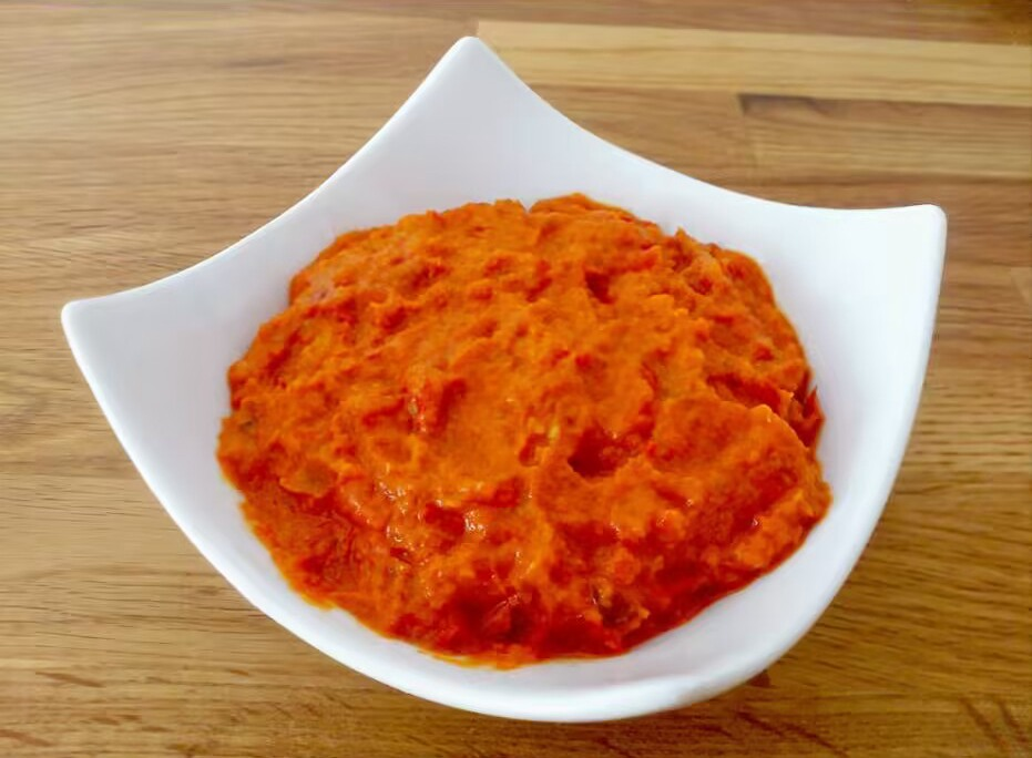 Bowl of homemade ajvar, traditional Serbian roasted red pepper spread with rich orange-red color and smooth texture