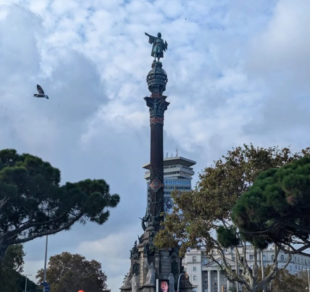 Tall Columbus monument column with statue pointing toward sea at end of Las Ramblas near Barcelona's old harbor area