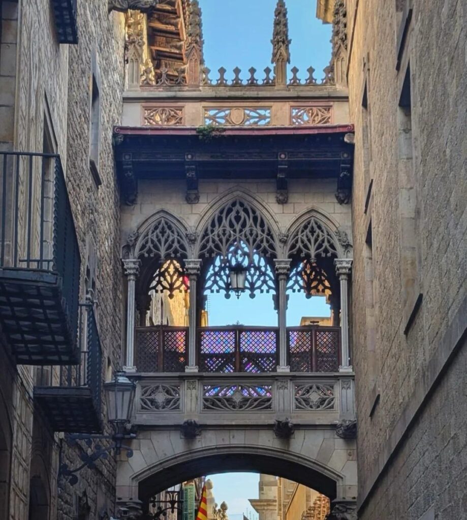 Famous neo-Gothic bridge connecting buildings across narrow medieval street in Barcelona's atmospheric Gothic Quarter