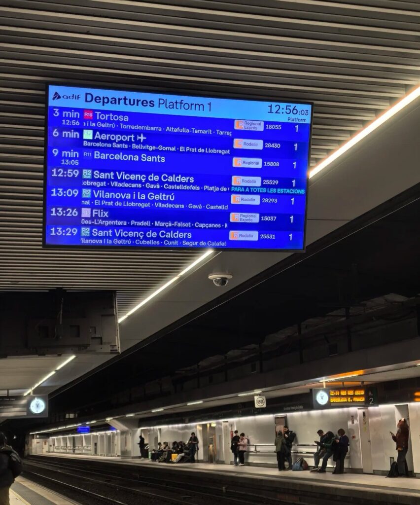 Digital departure board at Barcelona train station showing Renfe train schedules with destinations and platform information