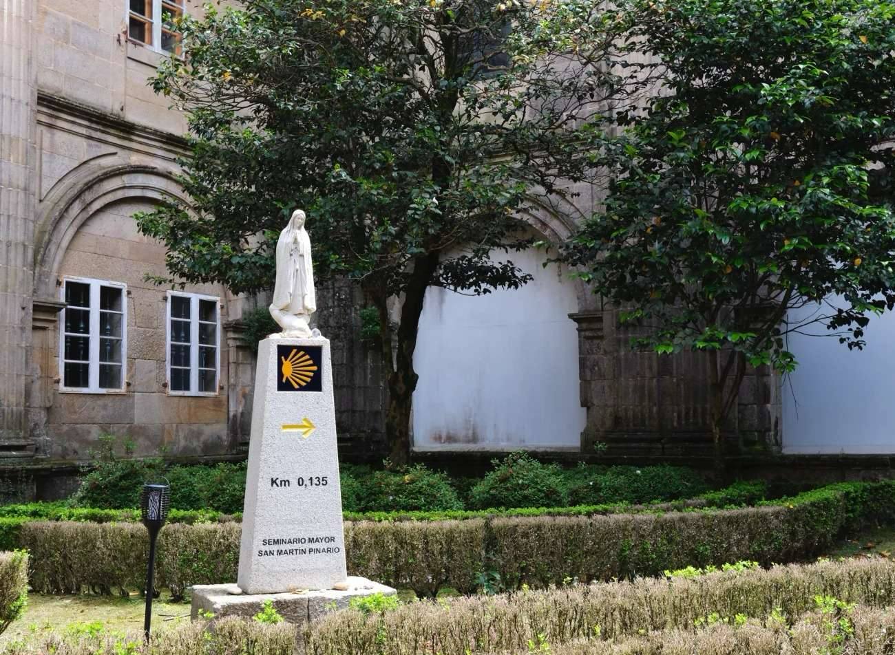 Final 0.135km marker to Santiago showing scallop shell symbol and yellow arrow for first-time pilgrims