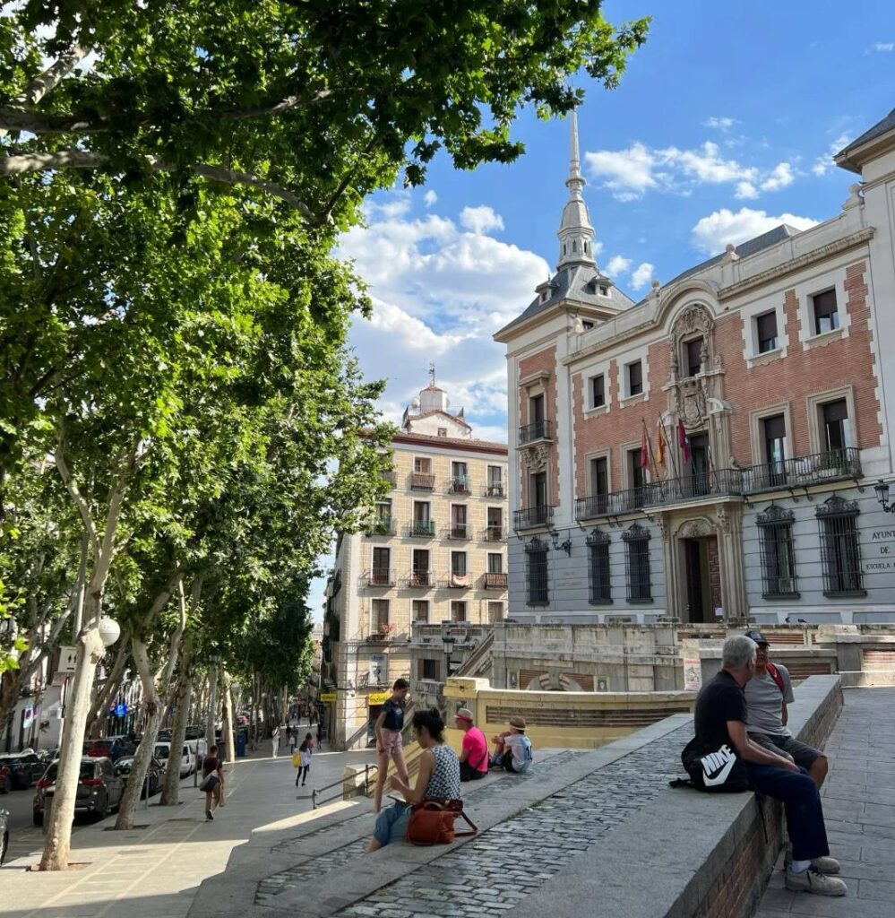 Historic Plaza de la Villa in Madrid with traditional architecture, city hall building, and visitors relaxing in the square