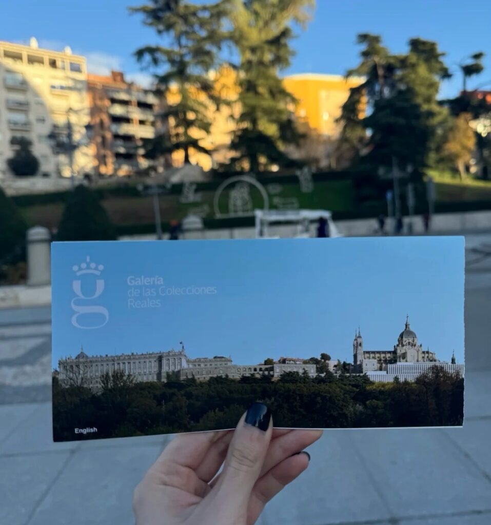 Tourist holding Madrid Royal Palace official guide brochure with palace overview and visitor information in English
