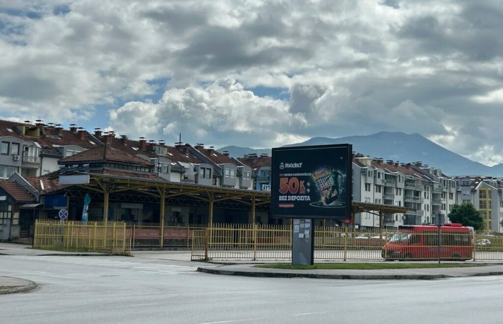 Serbian bus station with covered waiting area and mountain backdrop showing domestic transport infrastructure in smaller cities