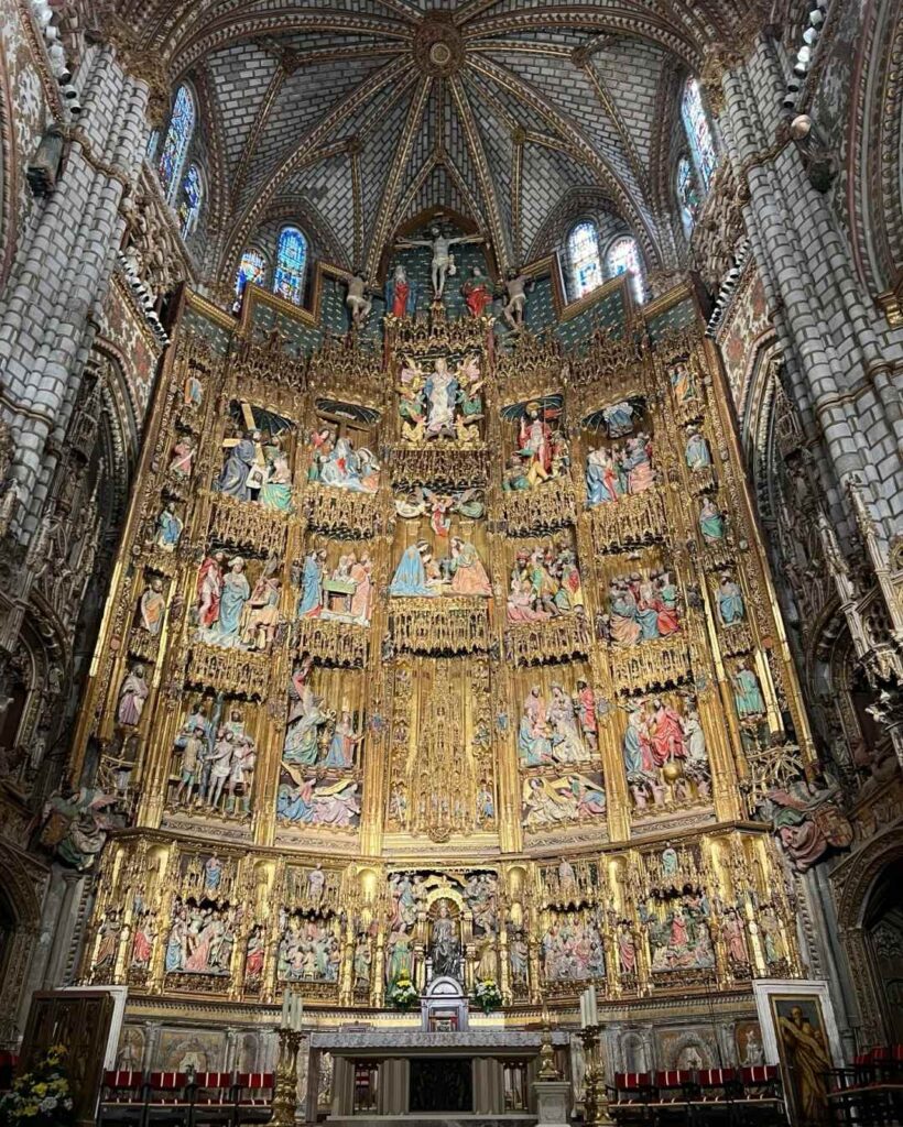Magnificent golden altarpiece retablo inside Toledo Cathedral featuring intricate biblical scenes and Gothic architecture