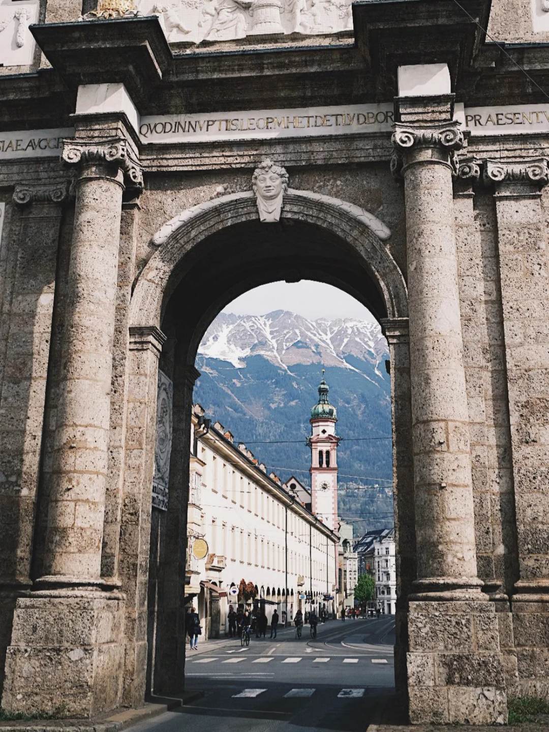 First-time solo travel historic European city gate with mountain backdrop
