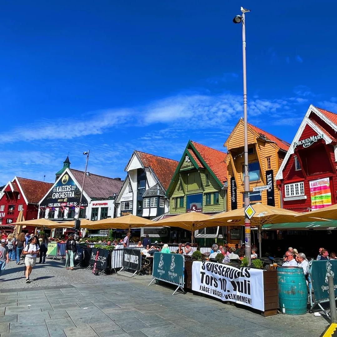 Norway drive final destination Bergen featuring colorful wooden houses at historic Bryggen wharf with outdoor dining