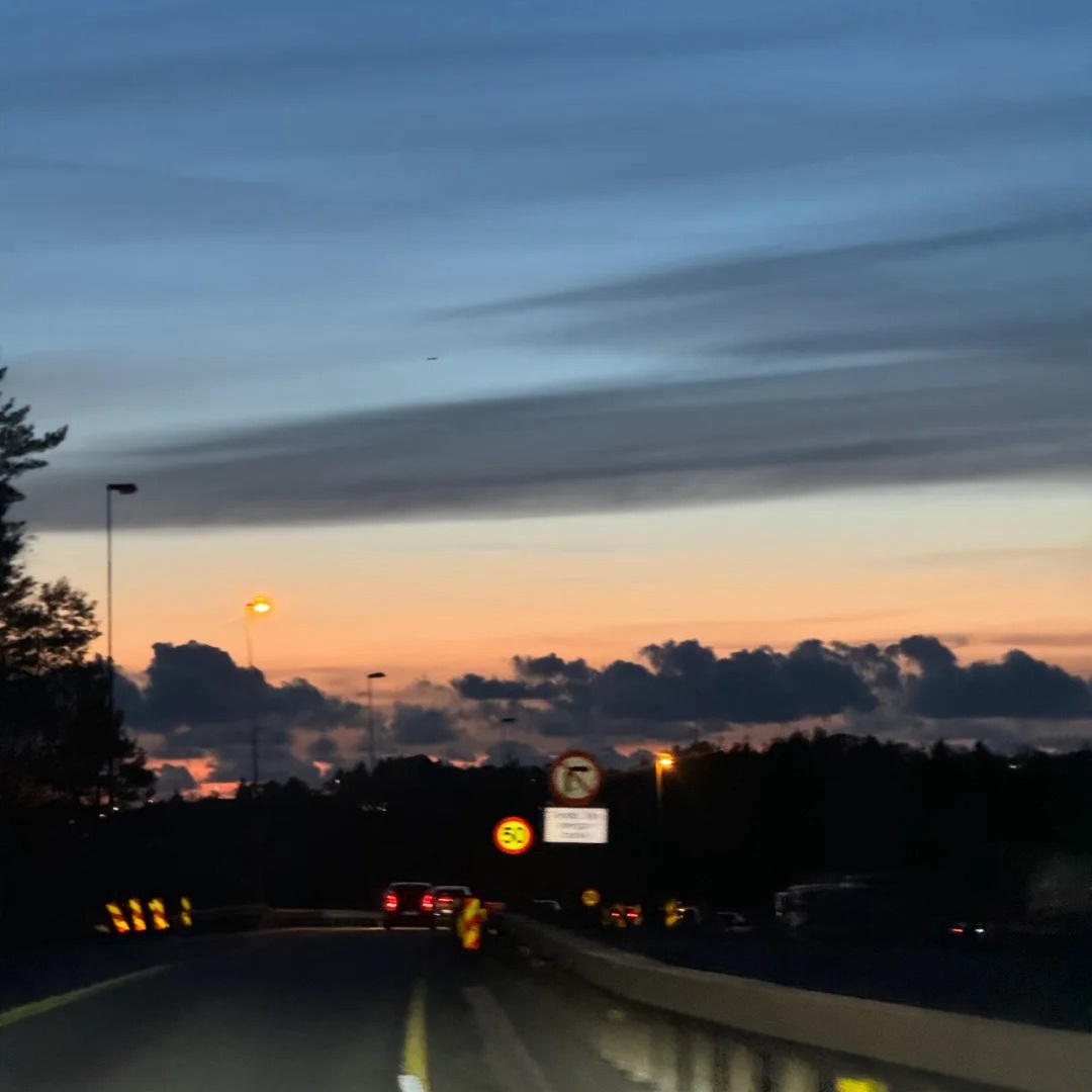 Norway road trip E39 highway during sunset with road signs and traffic showing scenic driving conditions