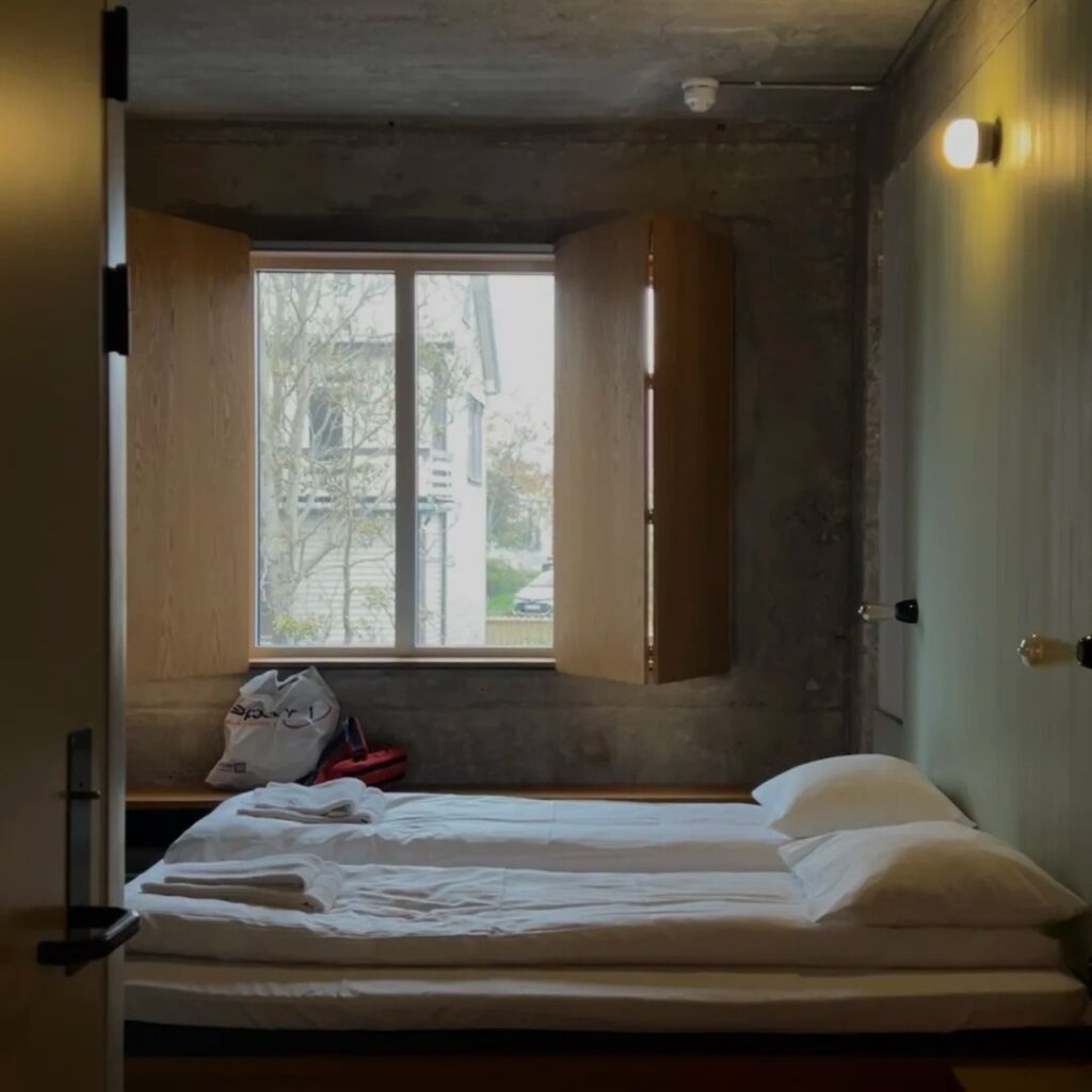 Norway stays modern hostel room with twin beds and large window showing budget accommodation option