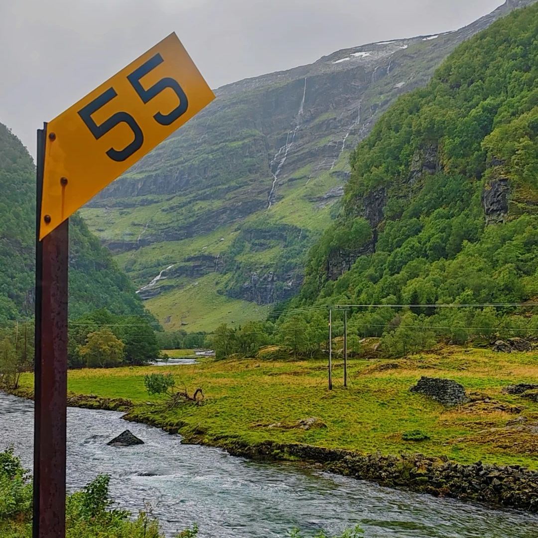 Norway travel scenic Route 55 road sign with dramatic mountain waterfalls and valley landscape