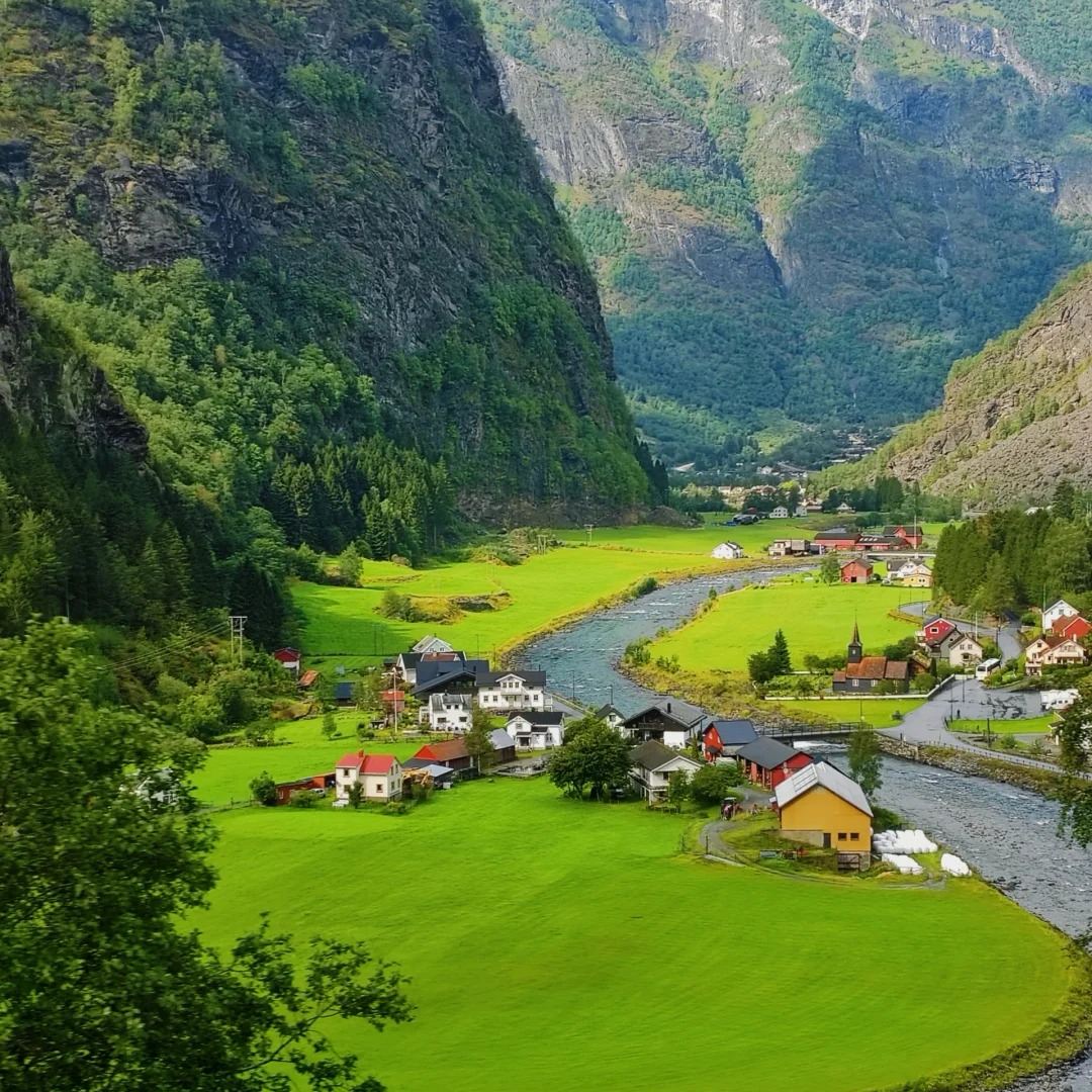 Norway travel traditional village nestled in green fjord valley with colorful houses and river