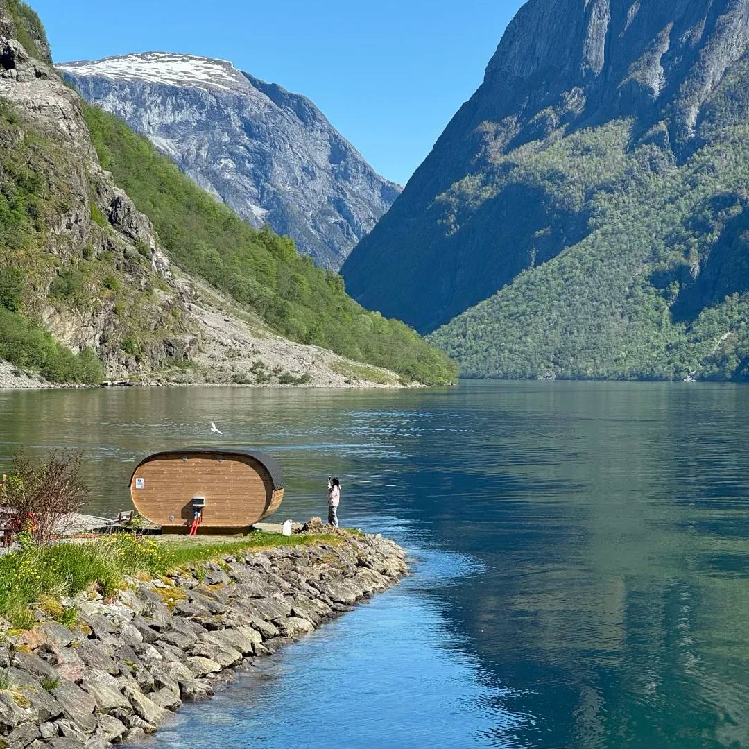Norway travel unique oval-shaped accommodation option beside pristine fjord with dramatic cliffs