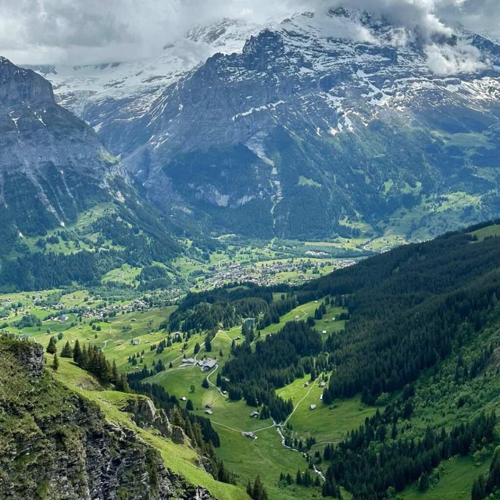 Switzerland travel tips mountain valley with snow peaks and village