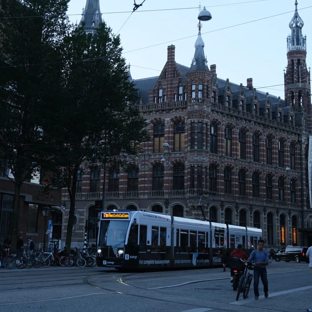 Amsterdam historic brick building with ornate architecture and modern tram system