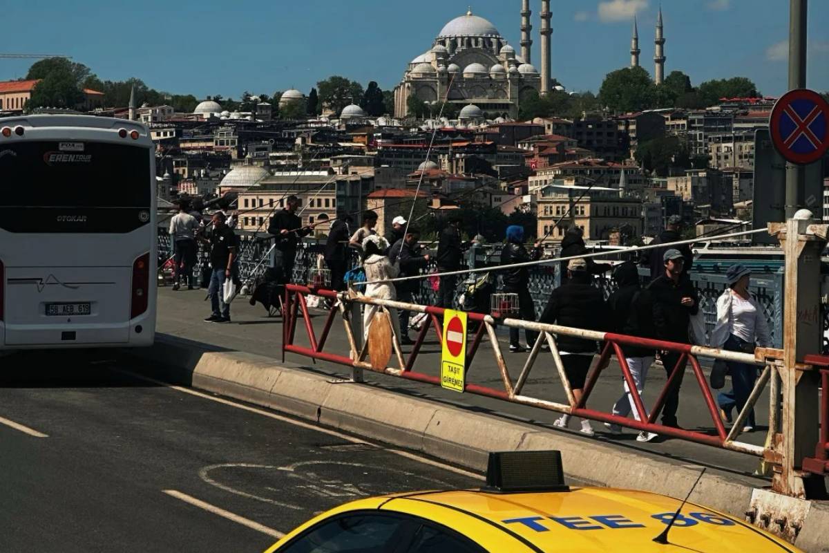 Traffic on Istanbul bridge with yellow taxi and historic Süleymaniye Mosque in background