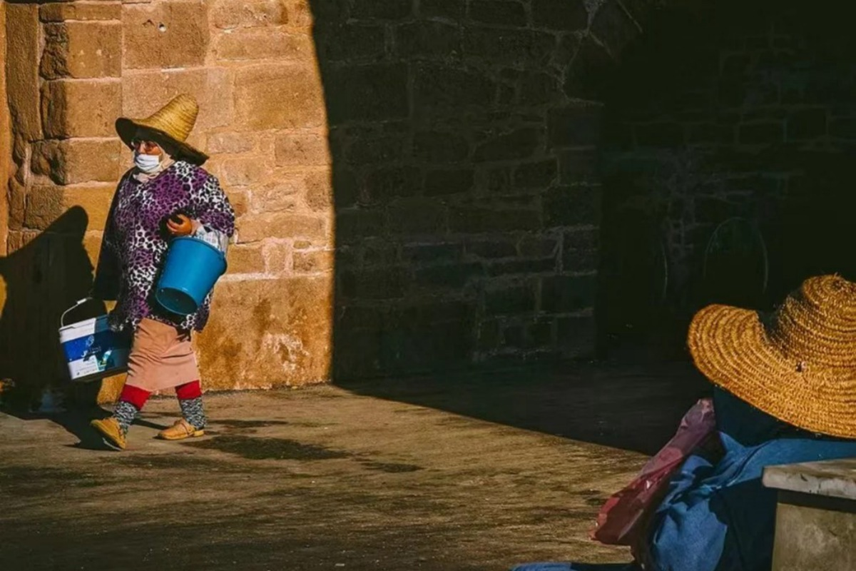 Moroccan women in traditional dress and straw hats at local market showing cultural practices year-round