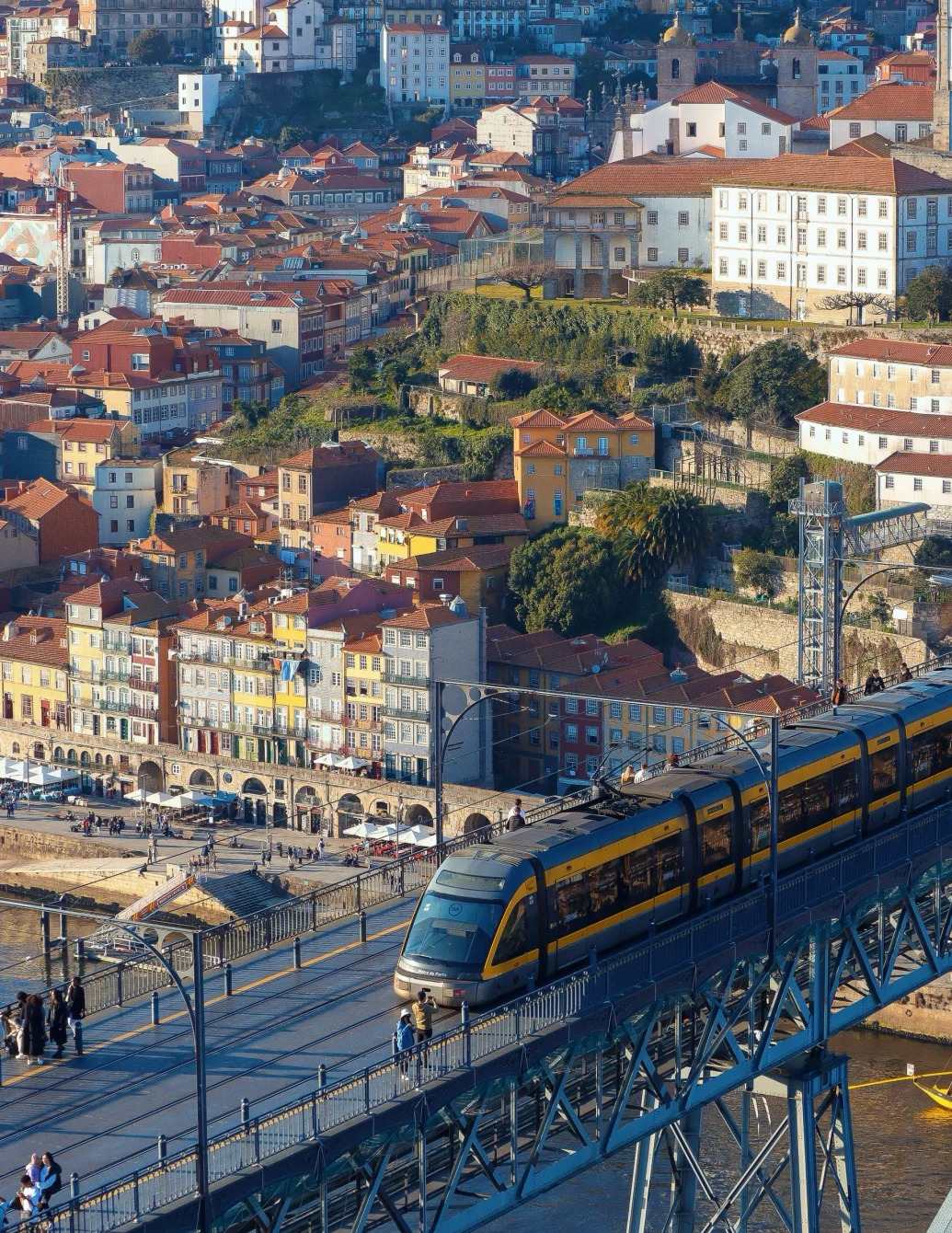 Porto tram on Dom Luís I Bridge with Ribeira district and Douro River in the background – Become A Traveller