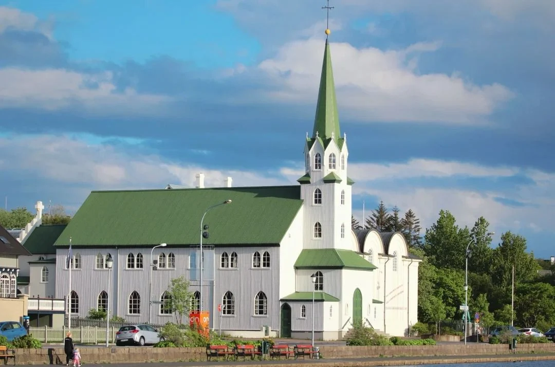 Traditional Icelandic church with distinctive green roof and white walls in Reykjavik city center"