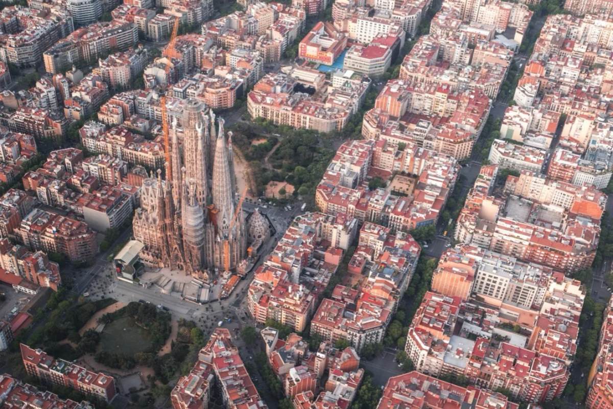 tunning aerial view of Barcelona's Sagrada Familia cathedral surrounded by characteristic Eixample district octagonal city blocks