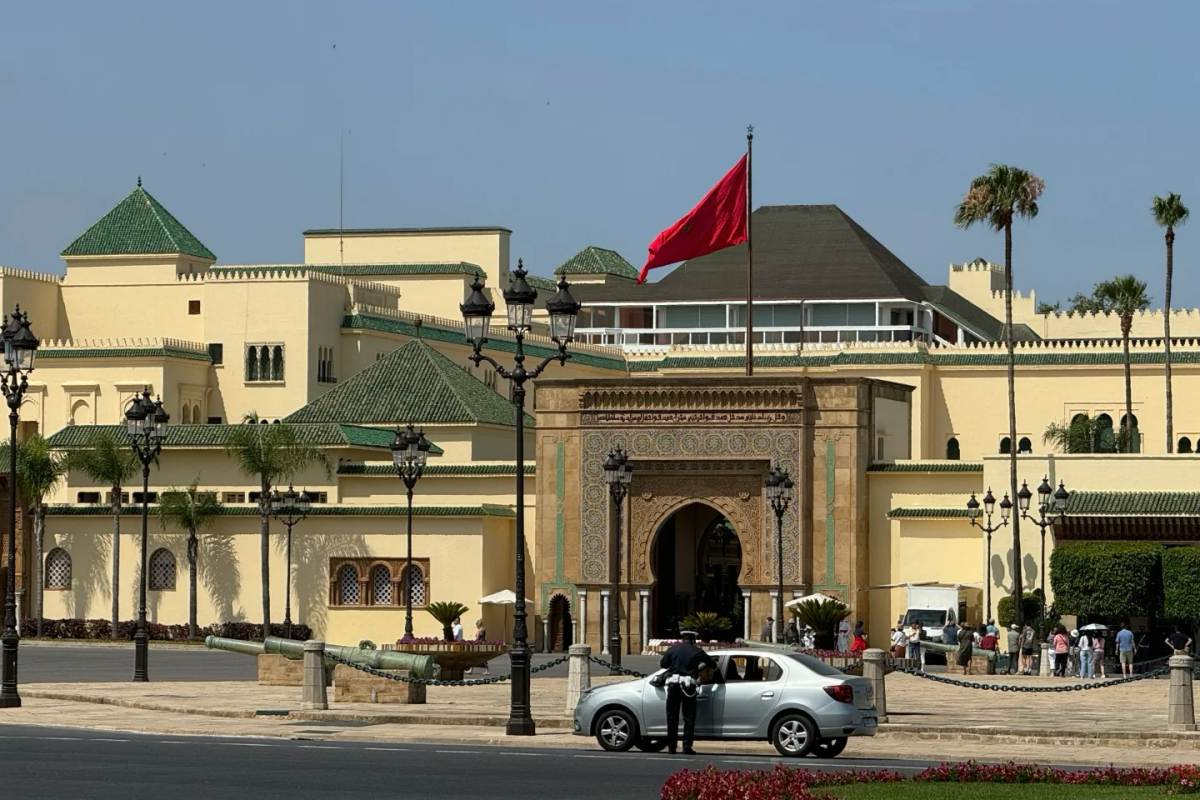 Traditional Moroccan architecture with green tile roofs and ornate archway entrance in Rabat, showing local transportation and visitors