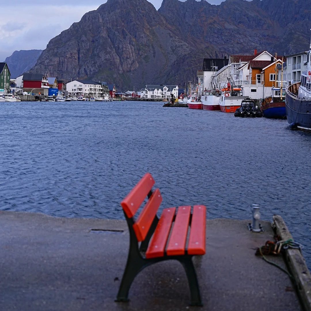 Norway stays location in picturesque fishing village with colorful houses red bench and mountain views