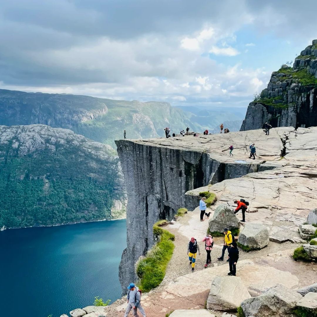 Norwegian fjords famous Pulpit Rock cliff platform with hikers overlooking Lysefjord from 604 meters high