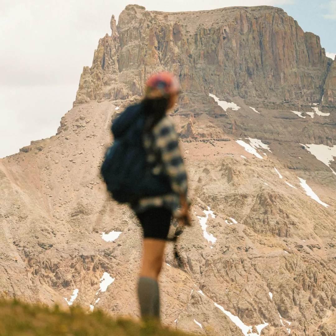 Solo female travel woman hiking with backpack in mountains