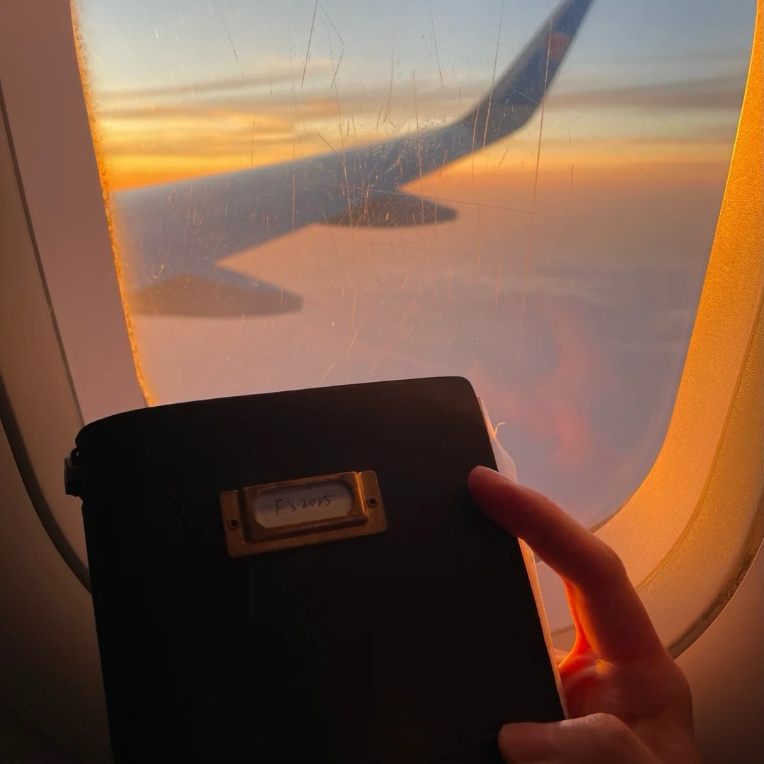 Solo female travelers airplane window passport at sunset