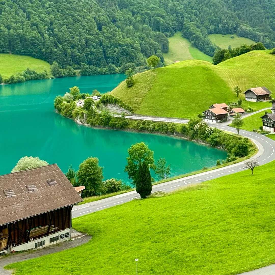 Switzerland travel tips pristine emerald lake with traditional chalets